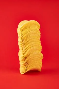 Stack of potato chips in bright red background Stock Photos