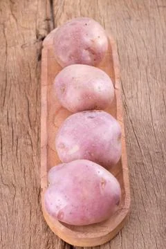 Stack of potatoes on wooden table (Solanum tuberosum) Stock Photos