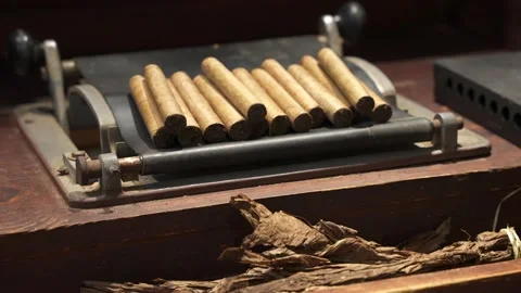 Stack of the premium cuban cigars on the hand roller tool. Most expensive cigars Stock Footage 233725040