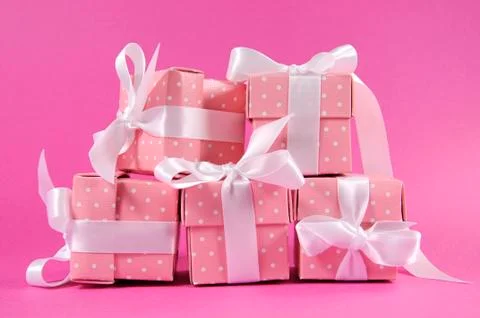 Stack of pretty pink polka dot present gift boxes with white ribbon for Chris Stock Photos