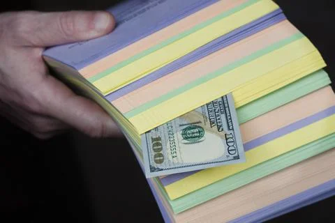 A stack of printed matter with a dollar bill. Earnings in the printing house. 스톡 사진