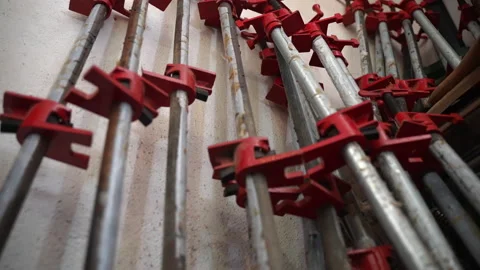 Stack of professional wood clamps in workshop leaning to the wall, heavy steel 스톡 동영상 163238017