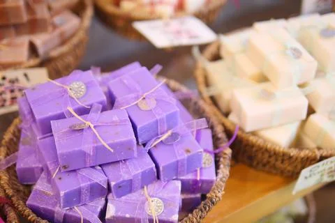 A stack of purple soaps with blue ribbons in a basket Stock Photos