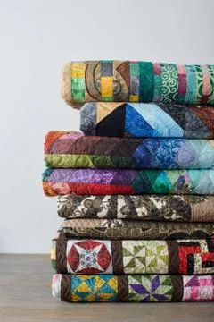 Stack of quilts on white wall background Fotos Stock