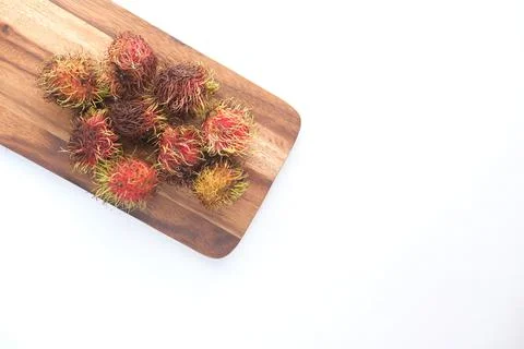 Stack of rambutan in a chopping board on white background 스톡 사진