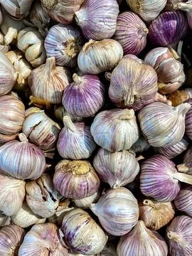 Stack of raw garlic in plastic container in market. Top view 写真素材
