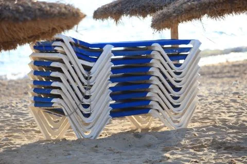 Stack of recliner chairs on a beach Stock Photos