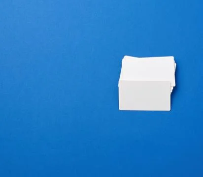 Stack of rectangular white blank business cards on a blue background 写真素材