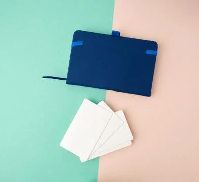 Stack of rectangular white blank business cards and blue notebook on a green  Stockfoto's