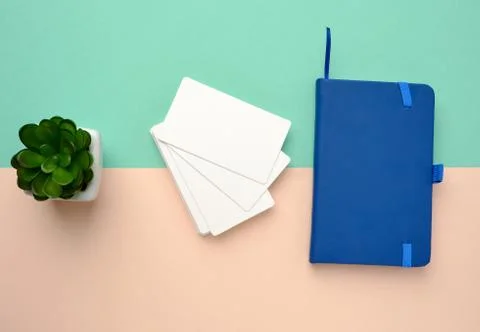 Stack of rectangular white blank business cards and blue notebook on a green  Stockfoto's