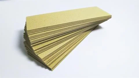 Stack of rectangular yellow paper strips on white background. Fotos Stock