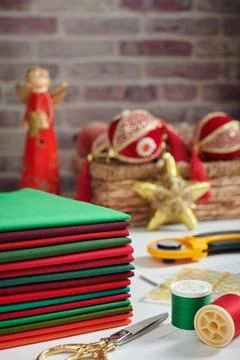 Stack of red and green fabrics, sewing and quilting accessories on Christma.. Stock-Fotos