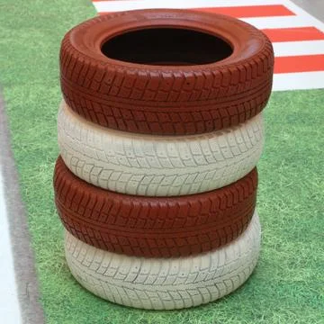 Stack of red and white tires fencing race track Stock Photos