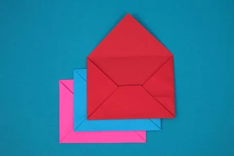 Stack of red, blue and pink envelopes on blue background Foto stock