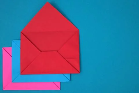Stack of red, blue and pink envelopes on blue background Foto stock