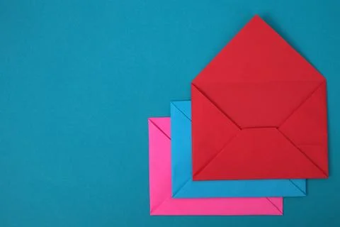Stack of red, blue and pink envelopes on blue background Foto stock