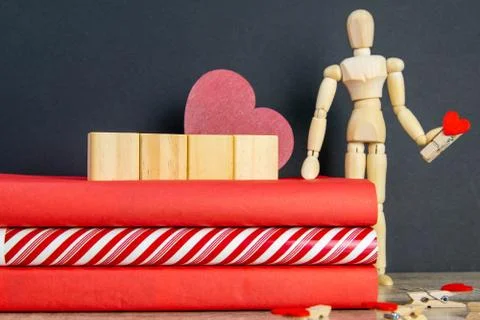 A stack of red books on which there are 4 wooden cubes, and next to there is  Stock Photos