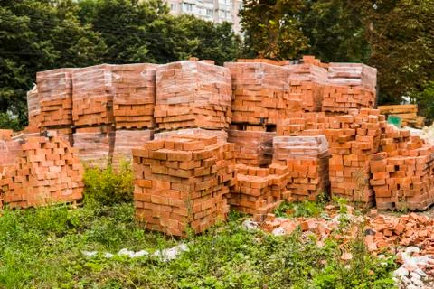 Stack of red brick for construction. Common quality building bricks stacked Stock Photos