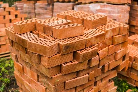 Stack of red brick for construction. Common quality building bricks stacked Stock Photos