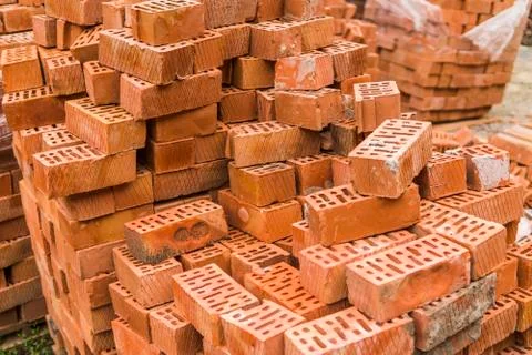 Stack of red brick for construction. Common quality building bricks stacked Stock Photos