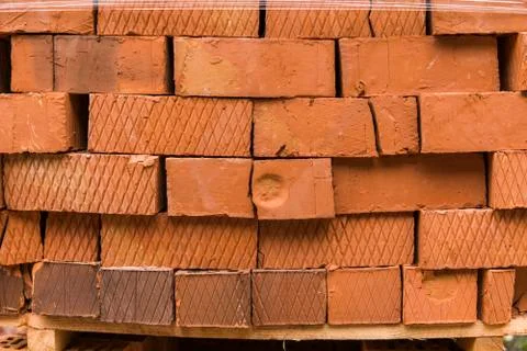 Stack of red brick for construction. Common quality building bricks stacked Stock Photos