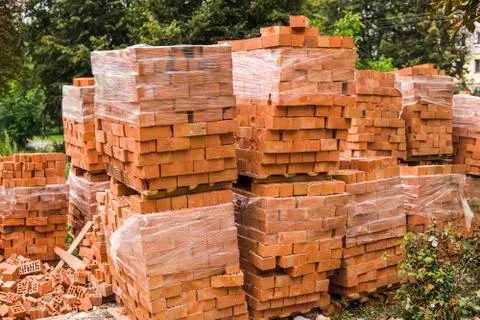 Stack of red brick for construction. Common quality building bricks stacked Stock Photos