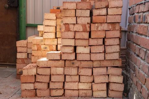 Stack of red bricks on concrete foundation, process of house building. Conc.. Foto stock