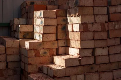 Stack of red bricks on concrete foundation, process of house building. Conc.. Stock Photos