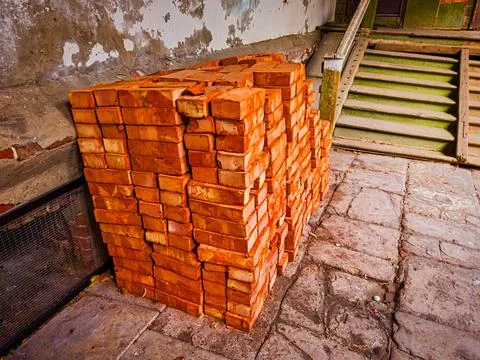 Stack of red bricks for construction purpose in the old house yard Stock Photos