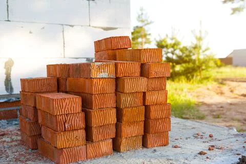 A stack of red bricks at a construction site. Construction materials, deliver Foto stock