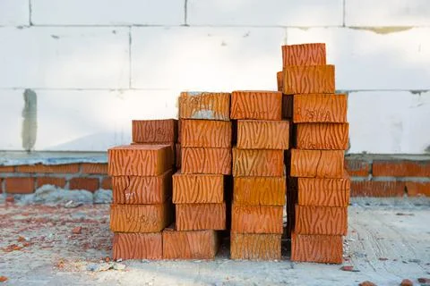 A stack of red bricks at a construction site. Construction materials, deliver Stock Photos