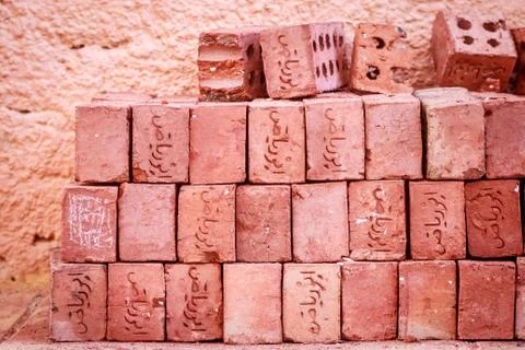 Stack of red bricks with inscriptions on the street of Egypt on a Sunny day Stock Photos