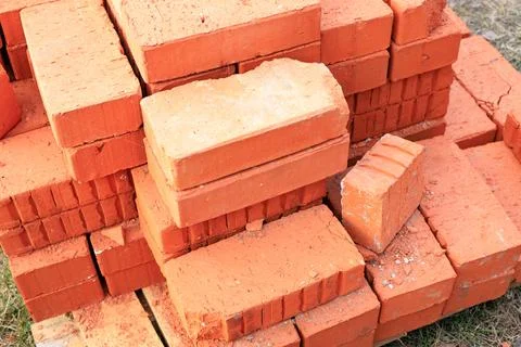 Stack of red ceramic bricks on a wooden pallet at a construction site. Stock Photos