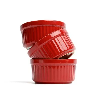 Stack of red ceramic round cupcake baking dishes isolated on white background Stock Photos