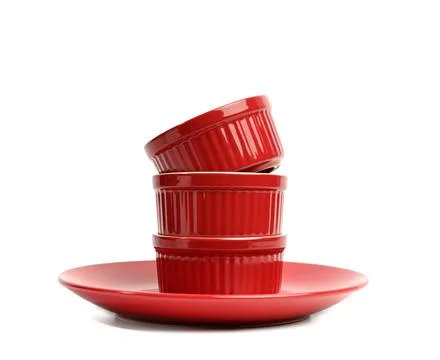 Stack of red ceramic round cupcake baking dishes isolated on white background Stock Photos