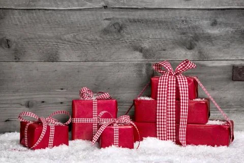 Stack of red christmas gifts,snow on grey wooden background. Stock Photos