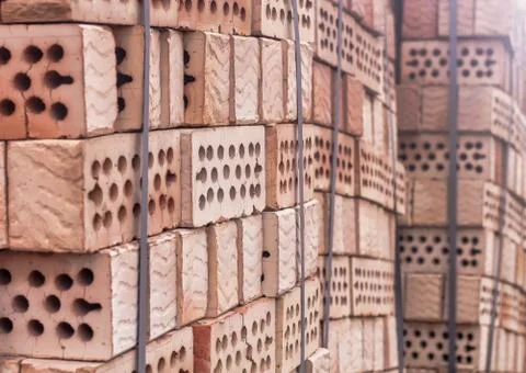 A stack of red clay bricks with holes Stock Photos