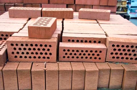 Stack of red clay bricks with holes Stock Photos