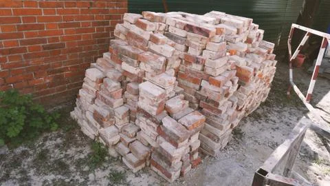 A stack of red clay bricks isolated on the floor Stock Photos
