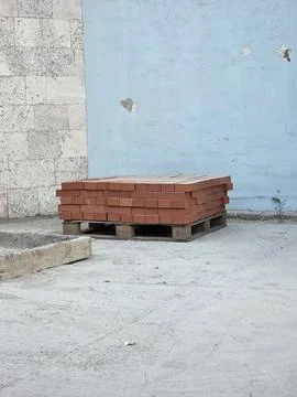 Stack of red clay bricks on wooden pallet outdoors. Stock Photos