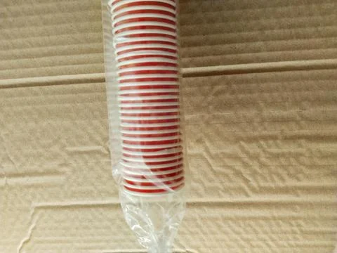 Stack of the red disposable cups isolated on brown background. It's an isol.. Stock Photos