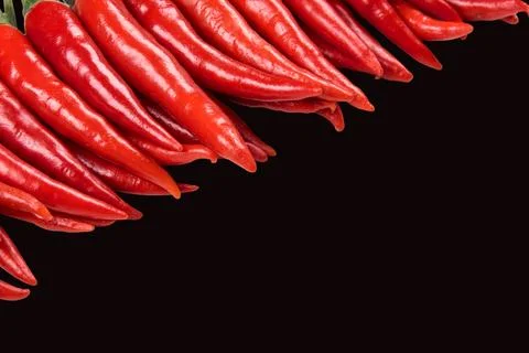 Stack of Red hot chilli pepper isolated on black background. Stock Photos