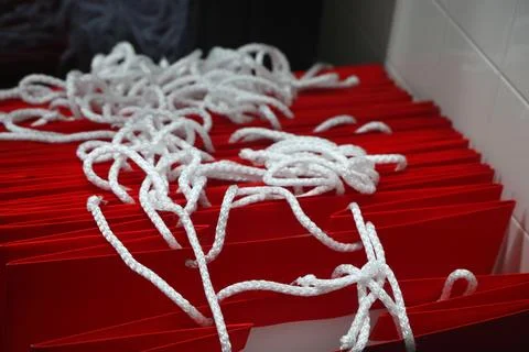 A stack of red paper bags with white rope handles. 스톡 사진