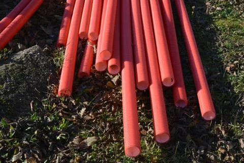 Stack red plastic electricity cable protection pipes Foto stock