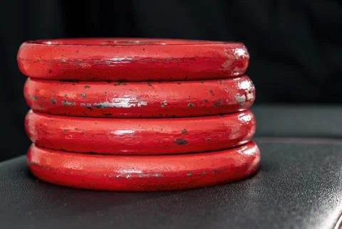 Stack of red weights on a black weight training bench Stock Photos