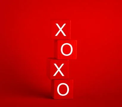 Stack of red wooden cubes with letters x and o on red background. Valentine.. 스톡 사진