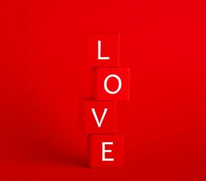 Stack of red wooden cubes with the text love on  red background. Valentine'.. Foto stock