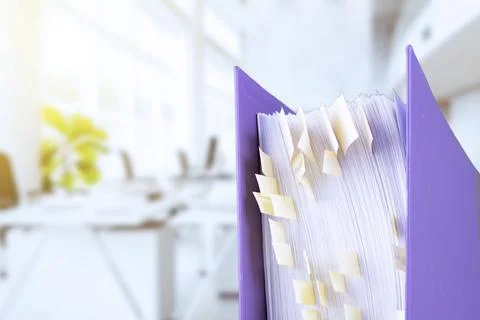 Stack of reporting paper documents in a purple folder with bookmarks on the d Stock Photos