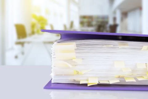 Stack of reporting paper documents in a purple folder with bookmarks on the d Stock Photos