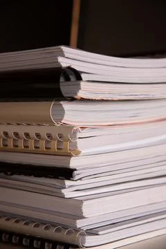 Stack of reports lies on a desk ready for review Stock Photos